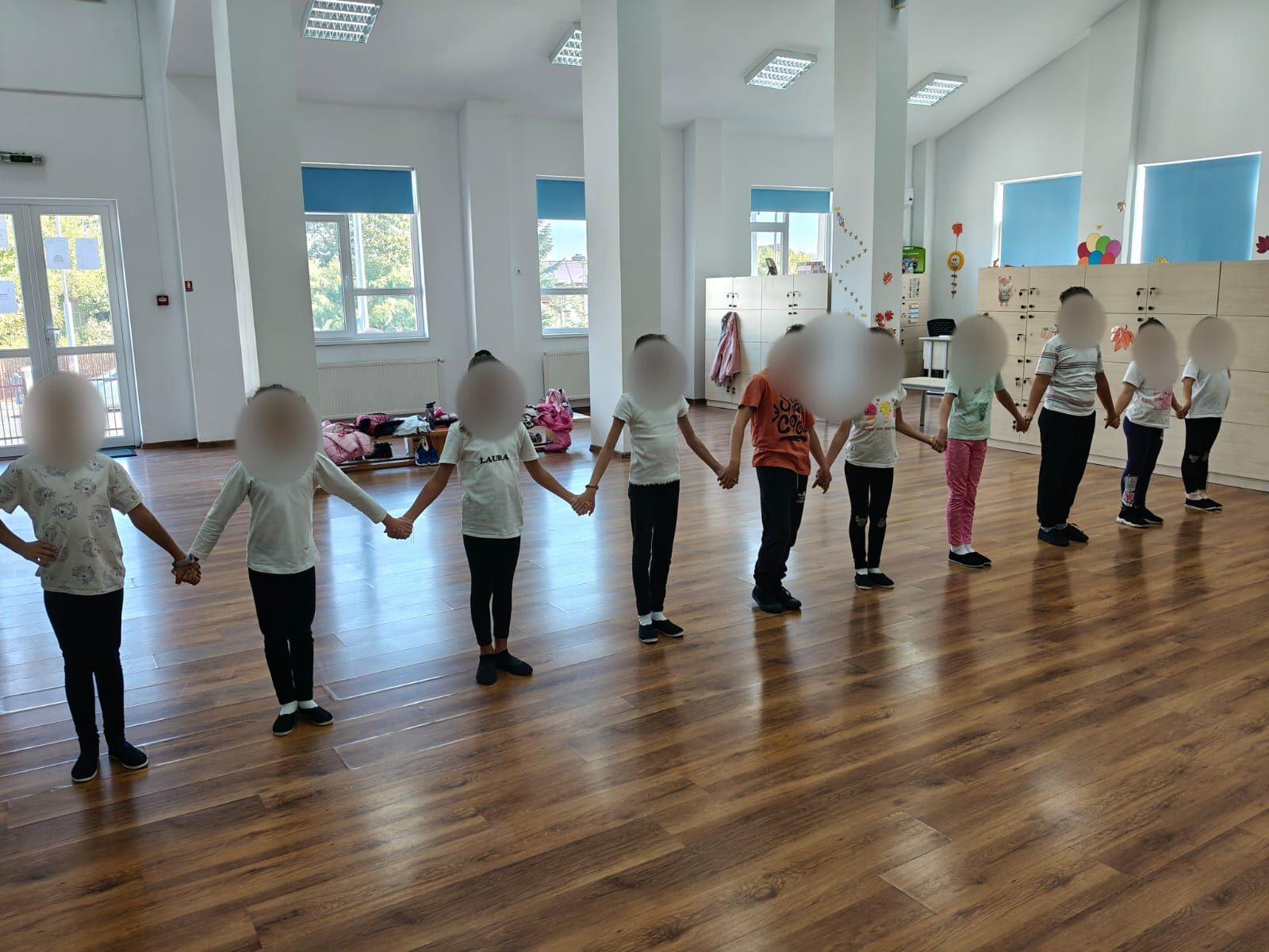 Copii dansând în echipă, cu fețele anonimizate